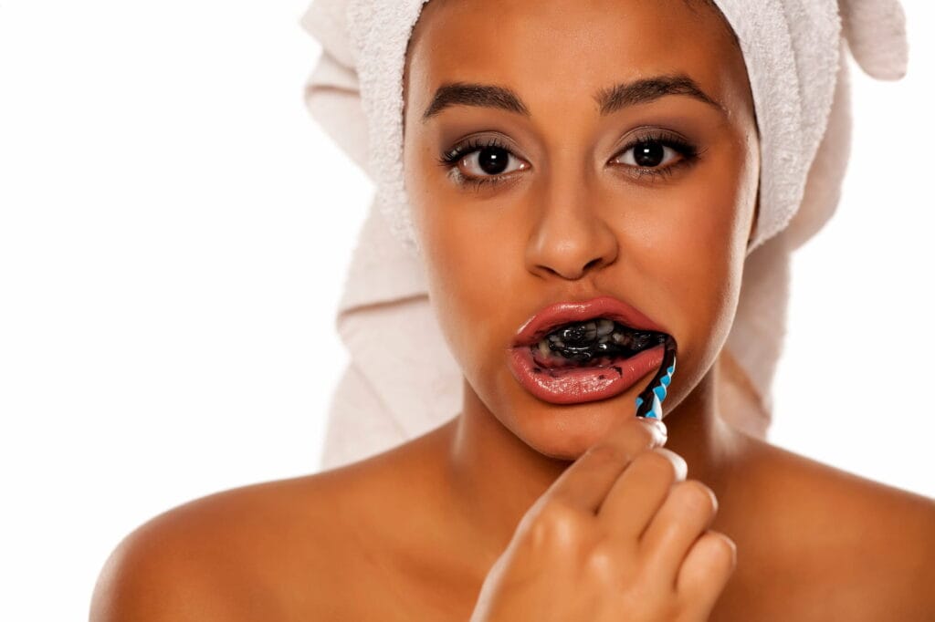 Woman wondering &ldquo;Is charcoal toothpaste bad for your teeth?