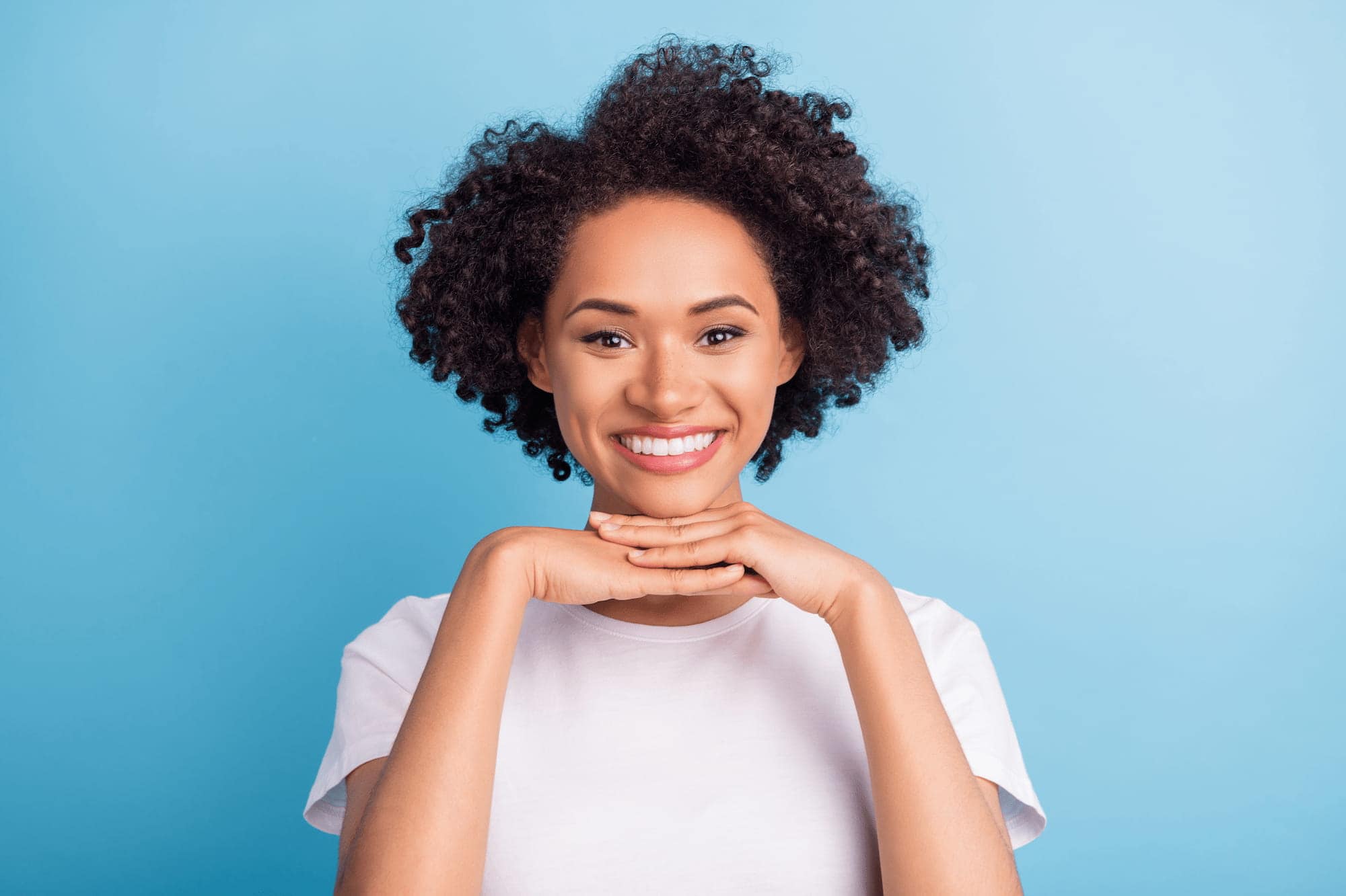 A woman with a vibrant smile shows off her pearly whites after receiving Invisalign in Highland Park.