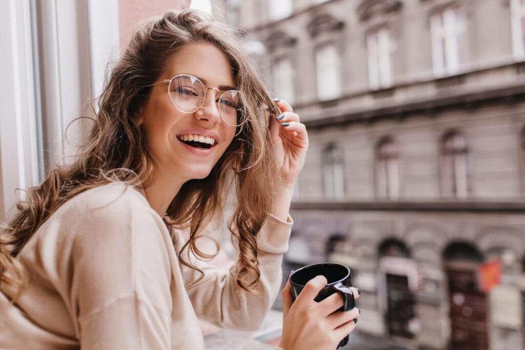 A woman admiring her teeth whitening before and after shade improvement