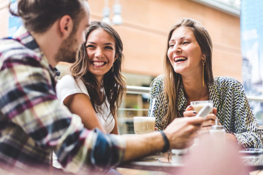 Woman wondering, &ldquo;Can braces improve my speech?&rdquo; while talking to friends
